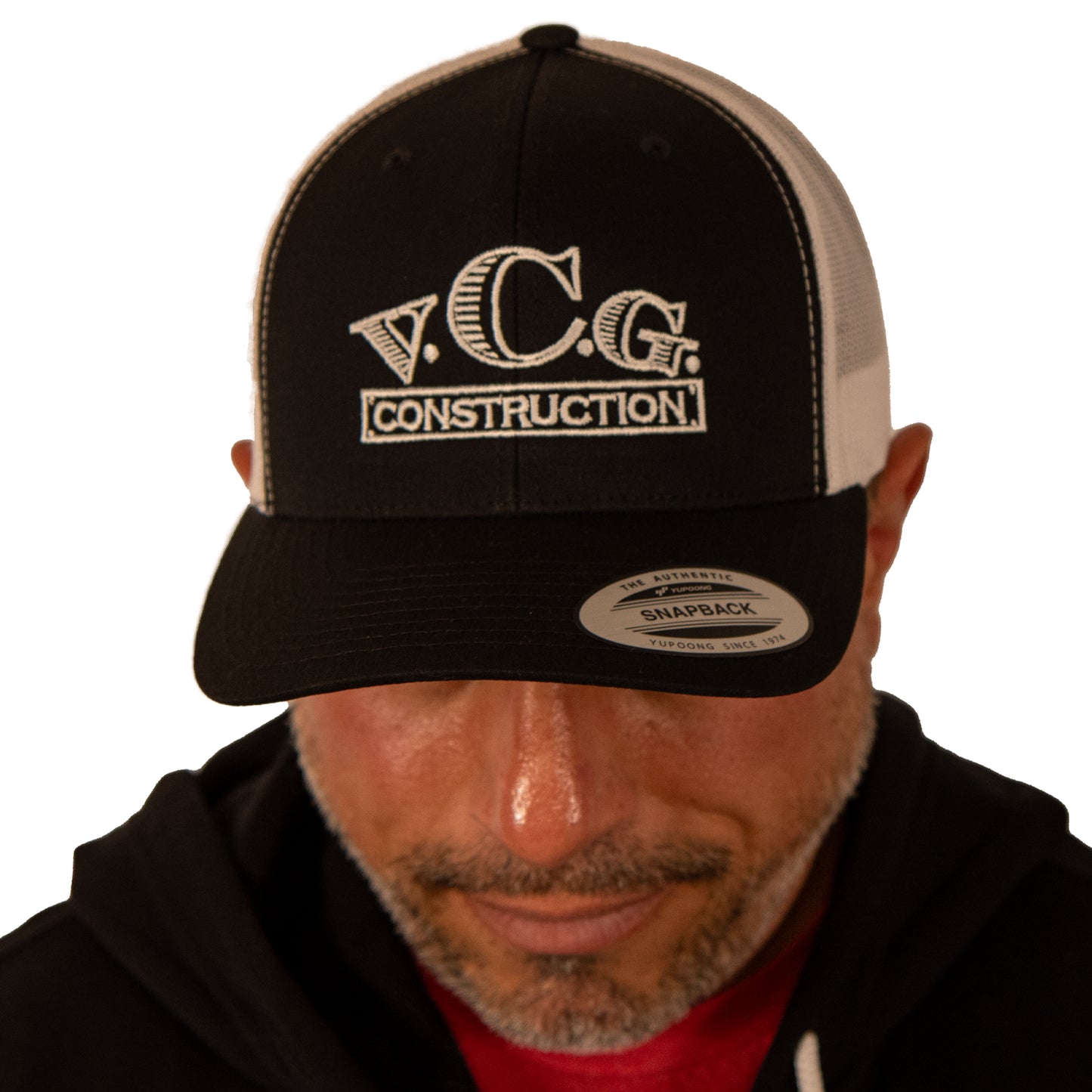 Model looking down wearing VCG Construction black and white snapback hat