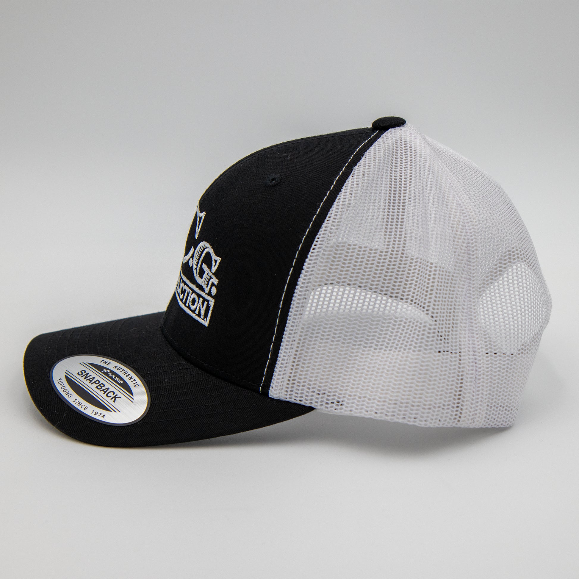 Side view of VCG Construction black and white snapback hat without a model