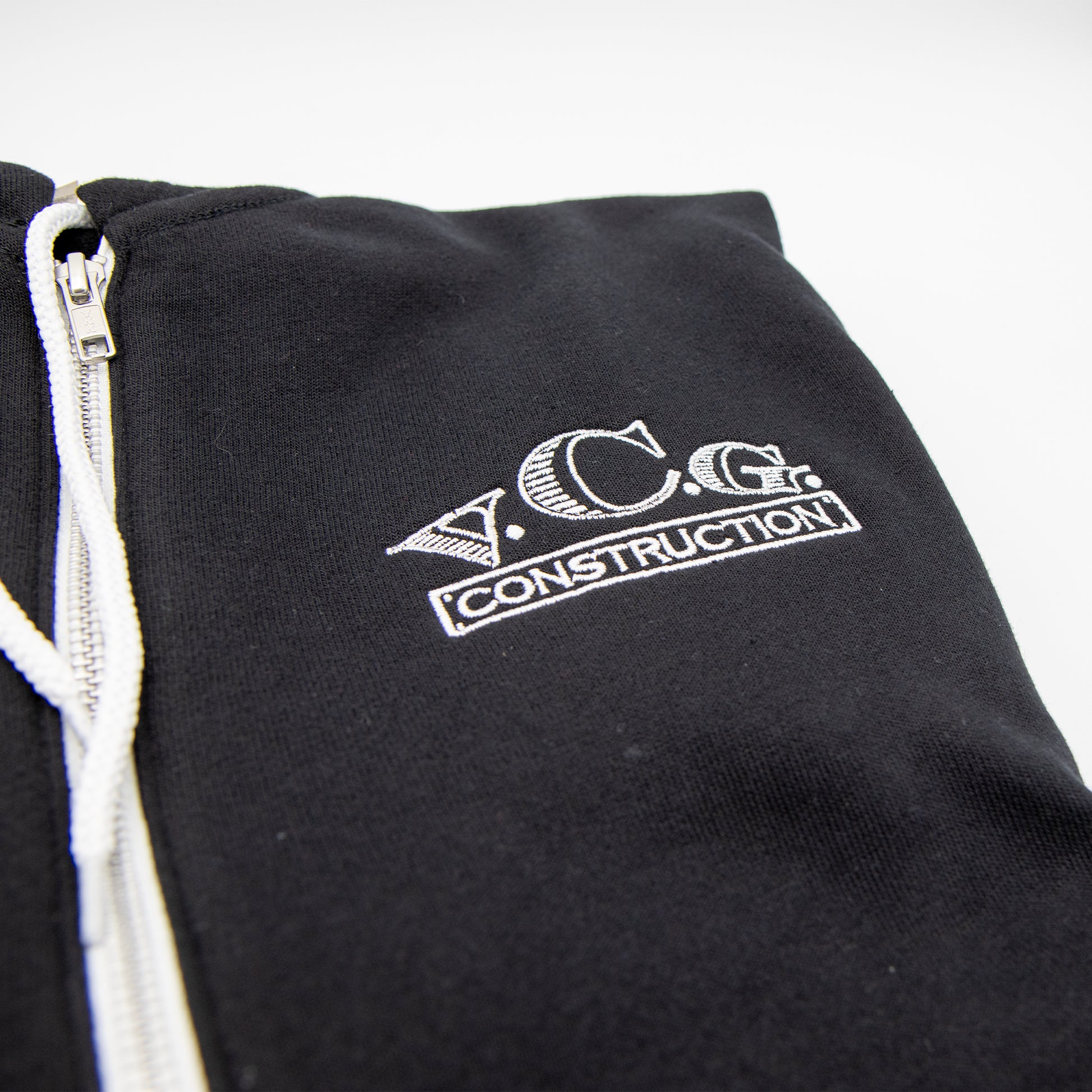 Flat lay of VCG Construction black zip-up hoodie with embroidered logo
