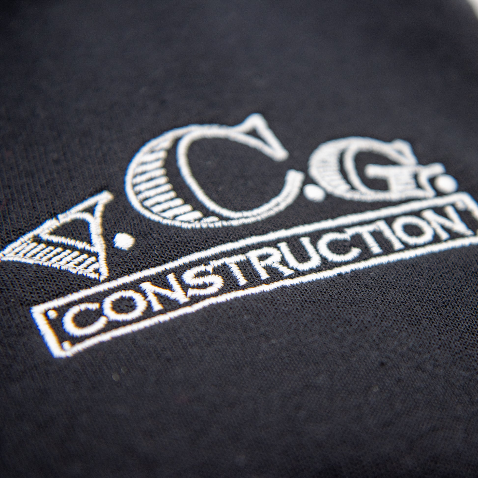 Zoom-in view of VCG Construction black hoodie embroidered logo