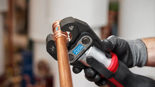 Close-up of the Milwaukee M12 FORCE LOGIC Press Tool with a 7/8” Streamline ACR Press Jaw securely connecting copper tubing, demonstrating the tool's precision and ease of alignment.