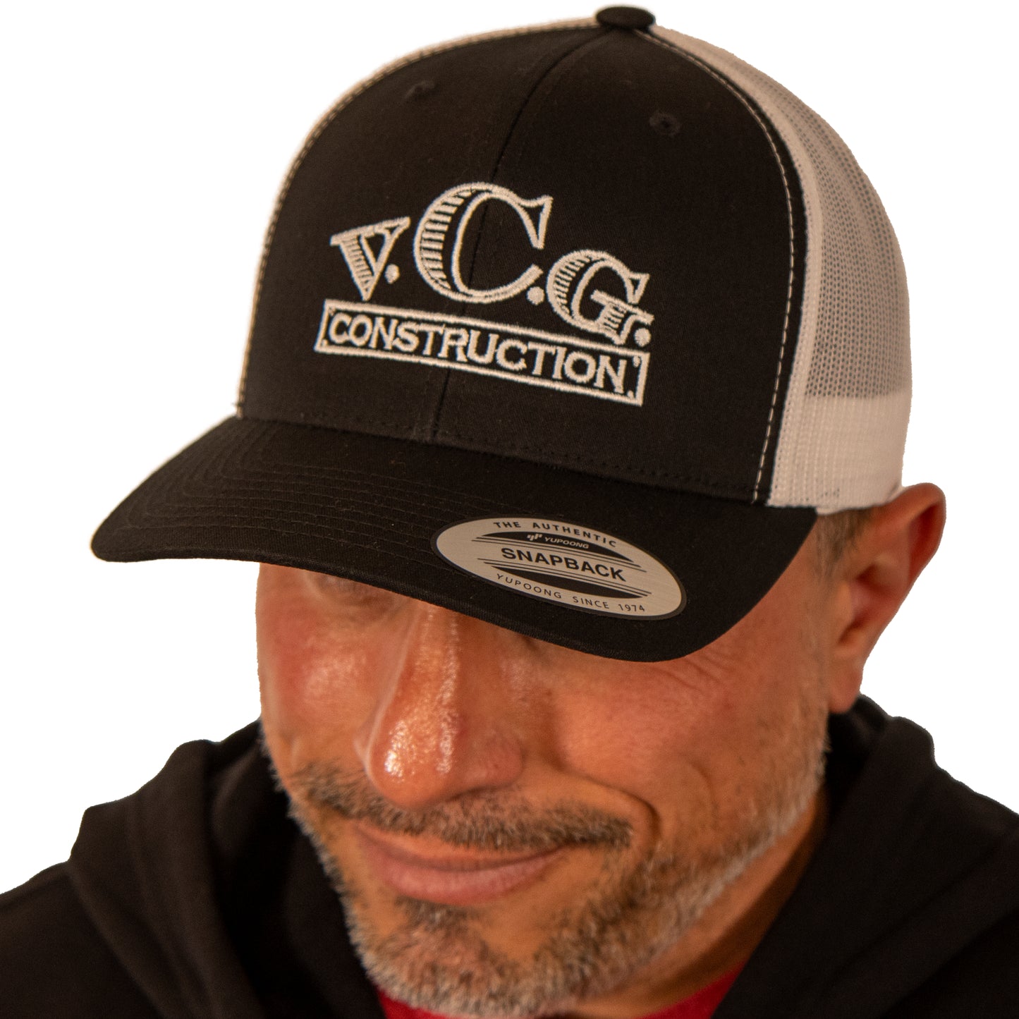 Model wearing VCG Construction black and white snapback hat with head tilted down