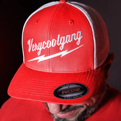 Experience the sleek appeal of our VERYCOOLGANG Thunderbolt logo, intricately embroidered in white on our two-tone Red and White Flexfit Trucker Mesh Cap.