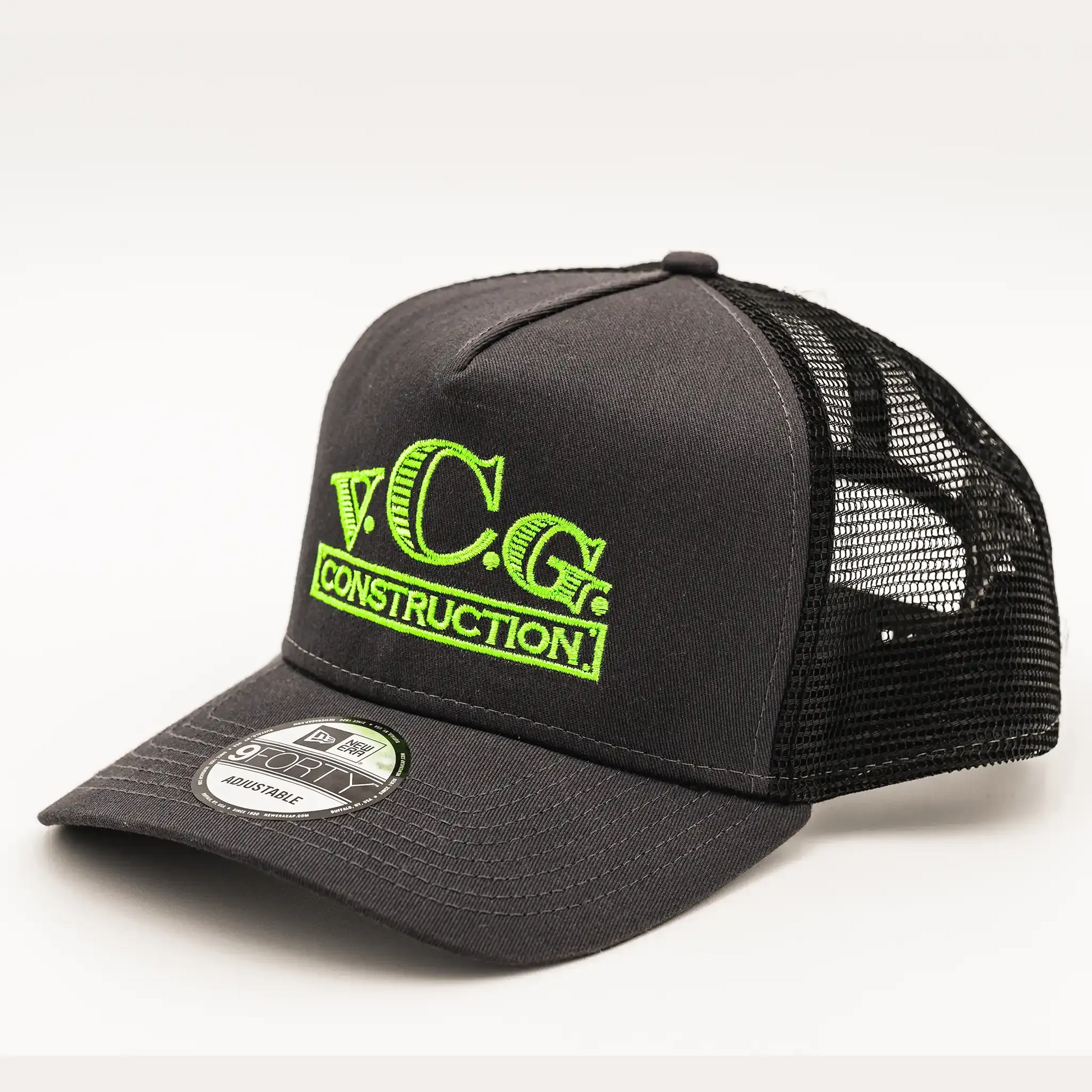 Snapback hat in graphite and black with a bold VCG Construction logo, accented by high-visibility green thread embroidery