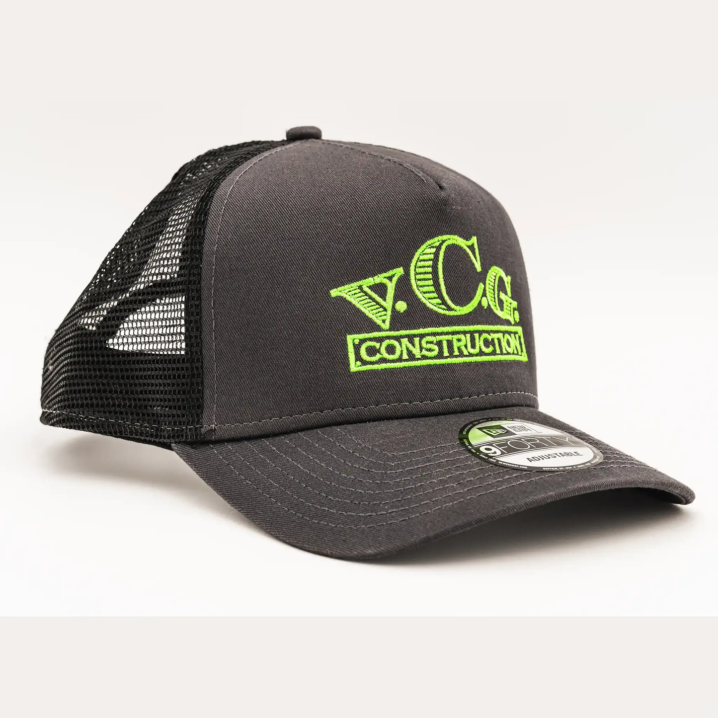 Graphite and black snapback hat with a VCG Construction logo embroidered in high-visibility green thread